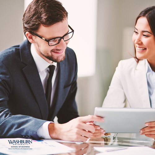 two people talking at laptop