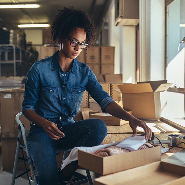 Person at table packaging an item to ship